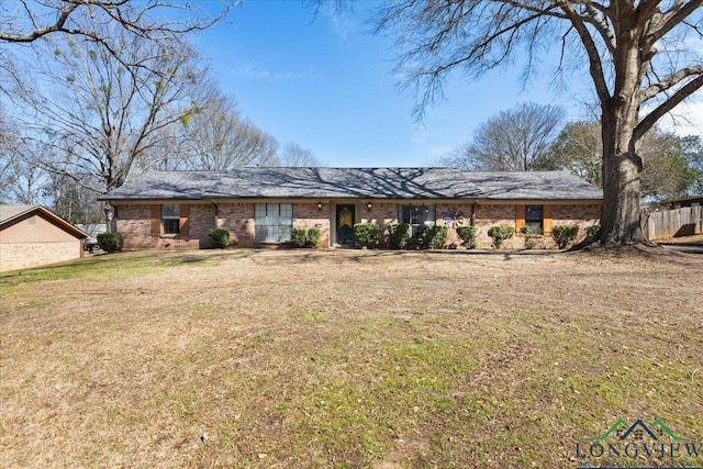 view of front of house with a front lawn, fence, and brick siding