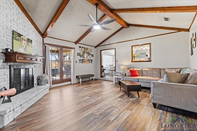 living area with light wood-style flooring, visible vents, a textured ceiling, and french doors