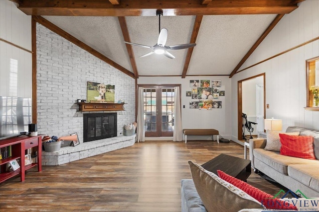 living room featuring a fireplace, lofted ceiling with beams, ceiling fan, a textured ceiling, and wood finished floors