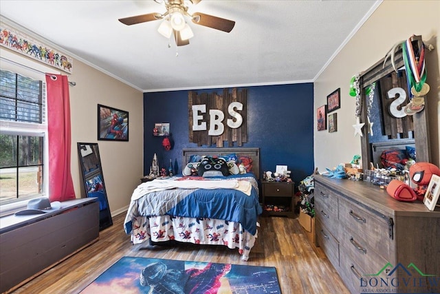 bedroom featuring baseboards, ceiling fan, ornamental molding, and wood finished floors