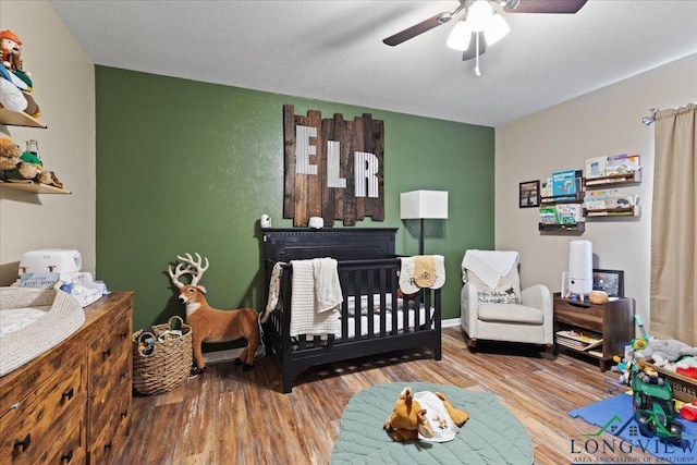 bedroom with a textured ceiling, wood finished floors, and a ceiling fan