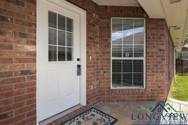 view of exterior entry with brick siding