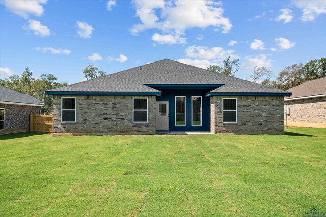 rear view of house featuring a lawn