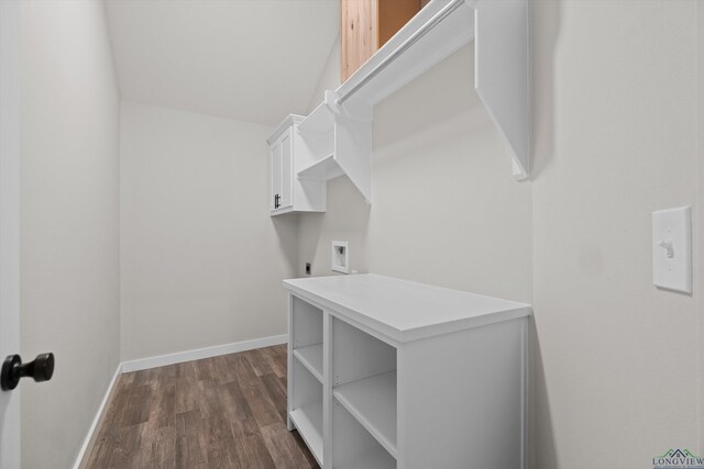 clothes washing area with dark hardwood / wood-style flooring, hookup for an electric dryer, and cabinets