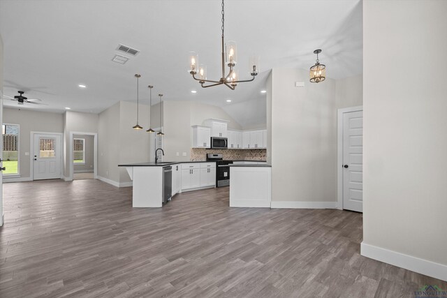 kitchen with appliances with stainless steel finishes, a kitchen island, white cabinetry, hanging light fixtures, and light hardwood / wood-style flooring