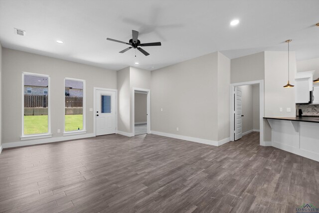 unfurnished living room with ceiling fan and wood-type flooring