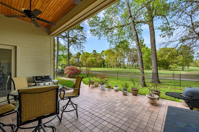 view of patio with outdoor dining area, a fenced backyard, a grill, and a ceiling fan