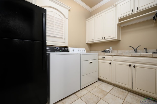 washroom with light tile patterned floors, crown molding, independent washer and dryer, cabinet space, and a sink