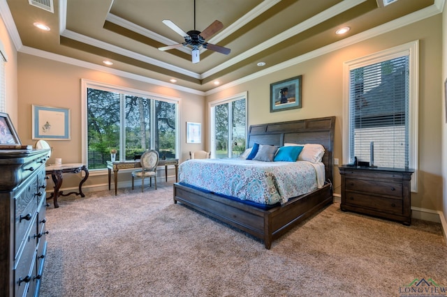 bedroom featuring crown molding, a tray ceiling, visible vents, carpet flooring, and baseboards