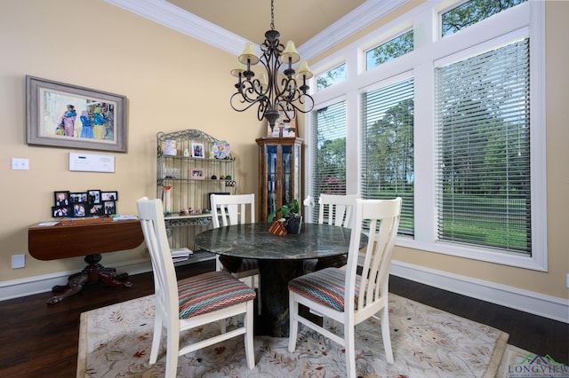 dining area featuring baseboards, an inviting chandelier, crown molding, and wood finished floors