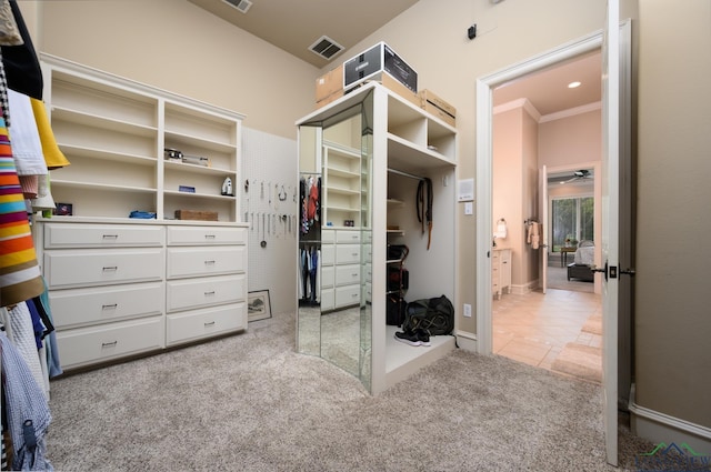 walk in closet with tile patterned flooring, carpet, visible vents, and a ceiling fan