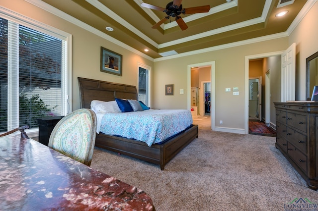 carpeted bedroom with crown molding, a tray ceiling, and multiple windows
