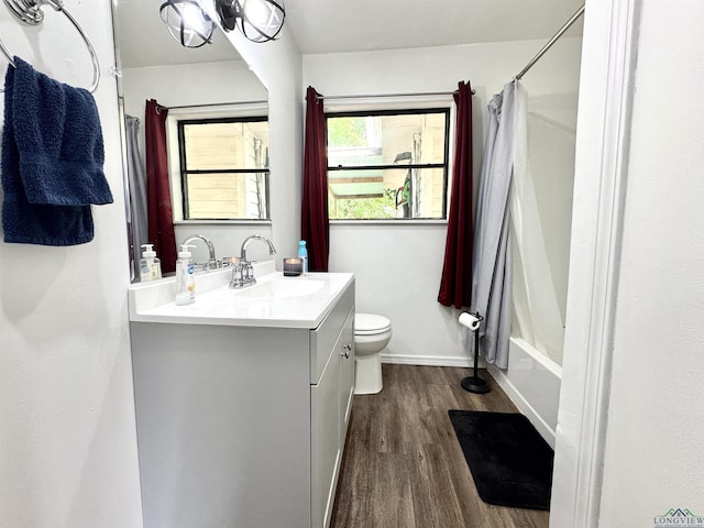 1612 Oden St, Longview, TX 75602 - full bathroom featuring wood finished floors, toilet, vanity, baseboards, and shower / tub combo