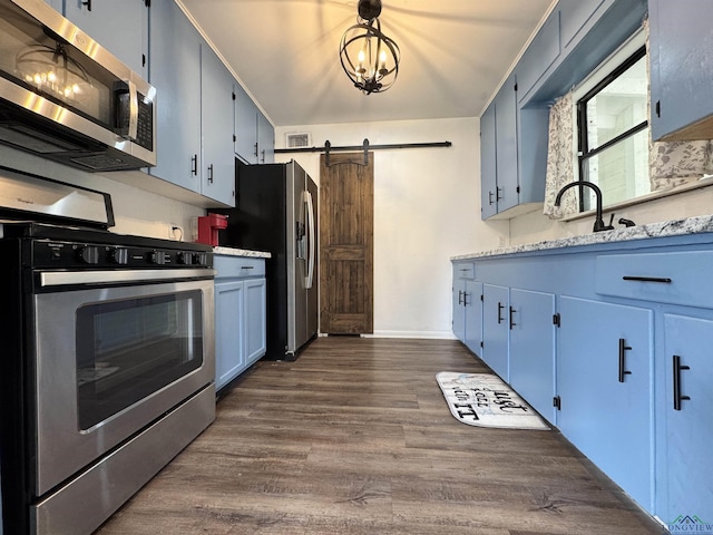 1612 Oden St, Longview, TX 75602 - kitchen with stainless steel appliances, blue cabinets, a barn door, dark wood finished floors, and a sink