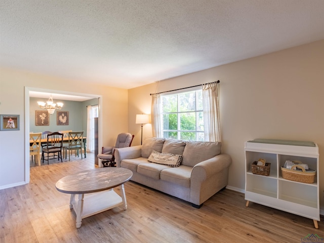 1900 Franklin Dr, Longview, TX 75601 - living room featuring a chandelier, wood finished floors, a textured ceiling, and baseboards
