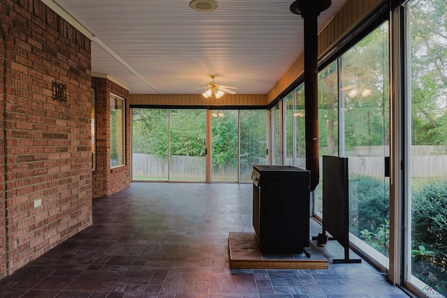 unfurnished sunroom with ceiling fan and a healthy amount of sunlight