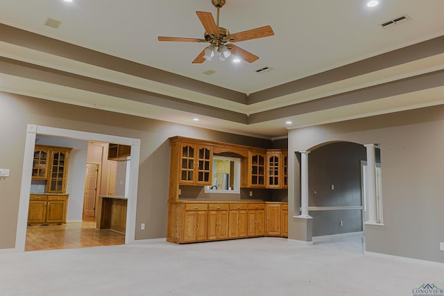 kitchen featuring decorative columns, crown molding, ceiling fan, and light colored carpet