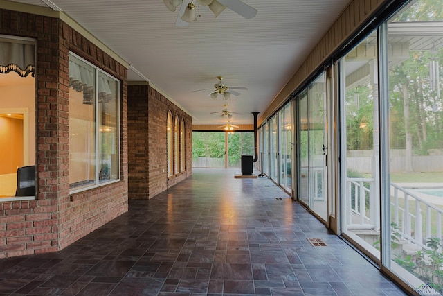 unfurnished sunroom with ceiling fan and a healthy amount of sunlight