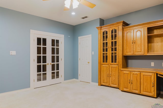 interior space featuring ceiling fan, french doors, and light colored carpet