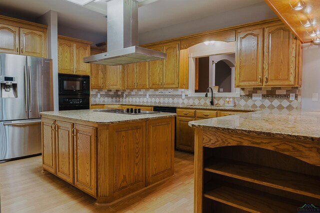 kitchen with a center island, sink, island exhaust hood, black appliances, and light wood-type flooring