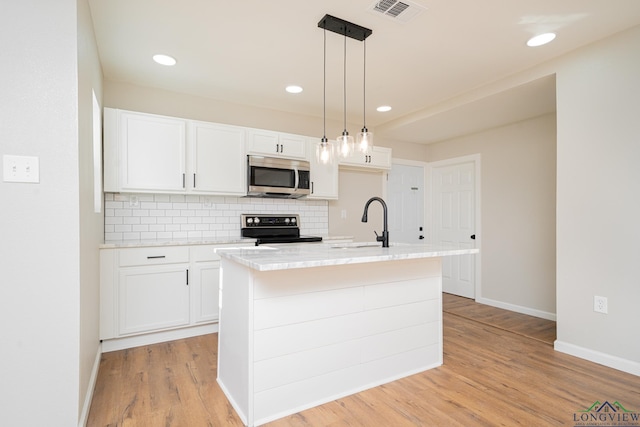 kitchen with sink, white cabinetry, decorative light fixtures, a center island with sink, and range with electric cooktop