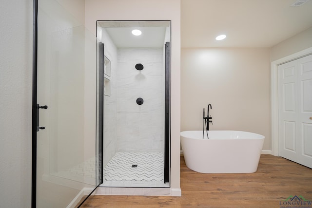 bathroom with hardwood / wood-style flooring and plus walk in shower