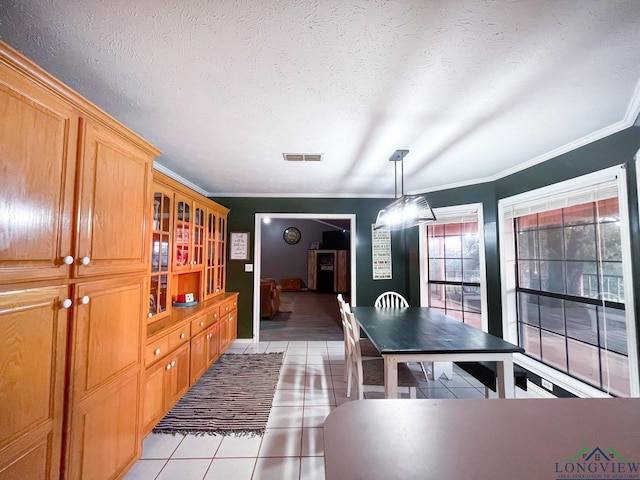 tiled dining room with crown molding and a textured ceiling