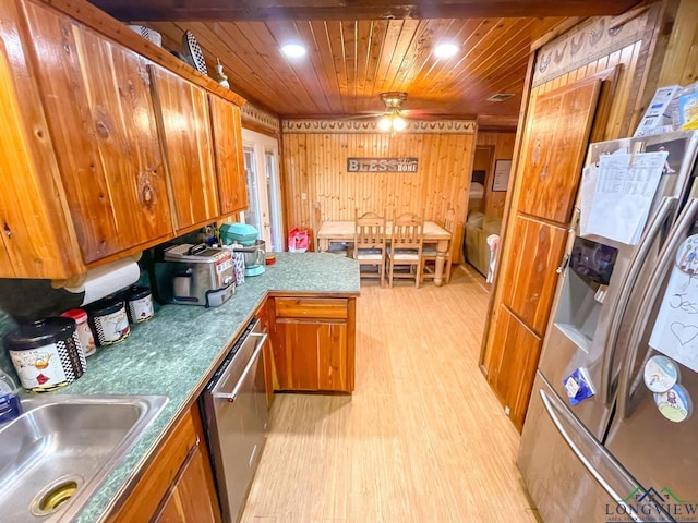 kitchen featuring wooden ceiling, sink, wooden walls, ceiling fan, and stainless steel appliances