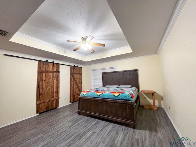 bedroom with a barn door, a raised ceiling, ceiling fan, and crown molding