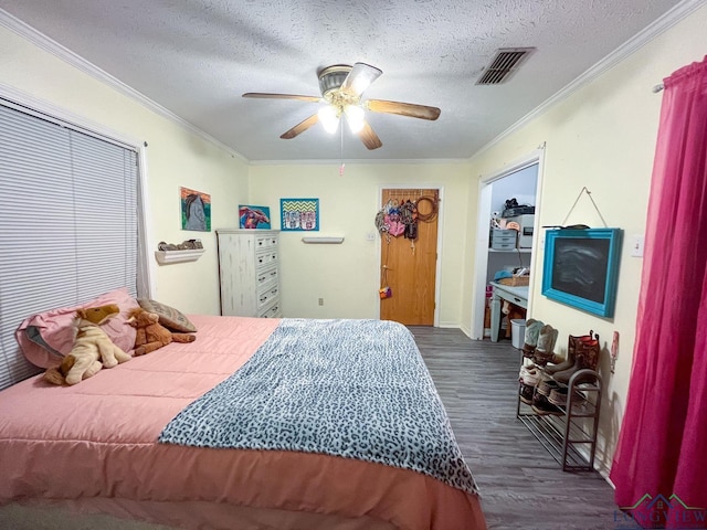 bedroom featuring ceiling fan, crown molding, a textured ceiling, and dark wood-type flooring