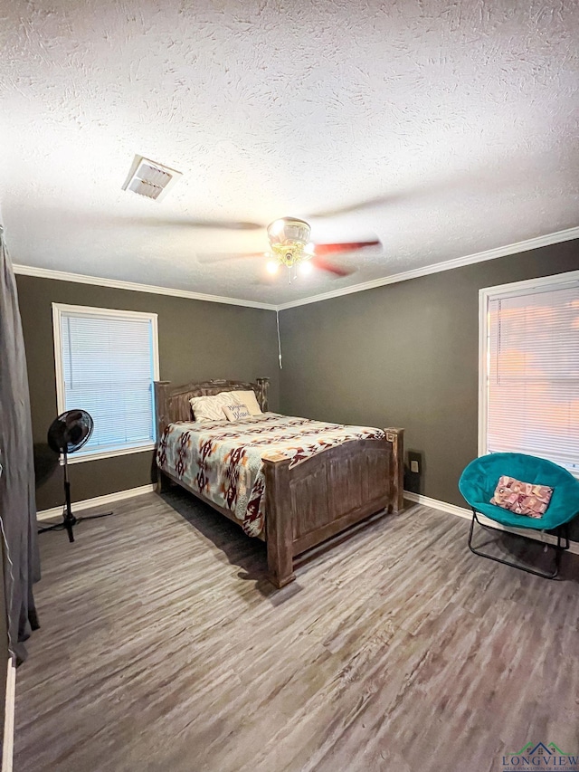 bedroom with hardwood / wood-style floors, ceiling fan, and ornamental molding