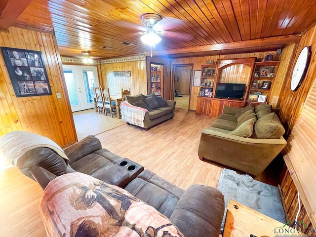 living room with ceiling fan, built in features, wooden walls, wood ceiling, and hardwood / wood-style flooring