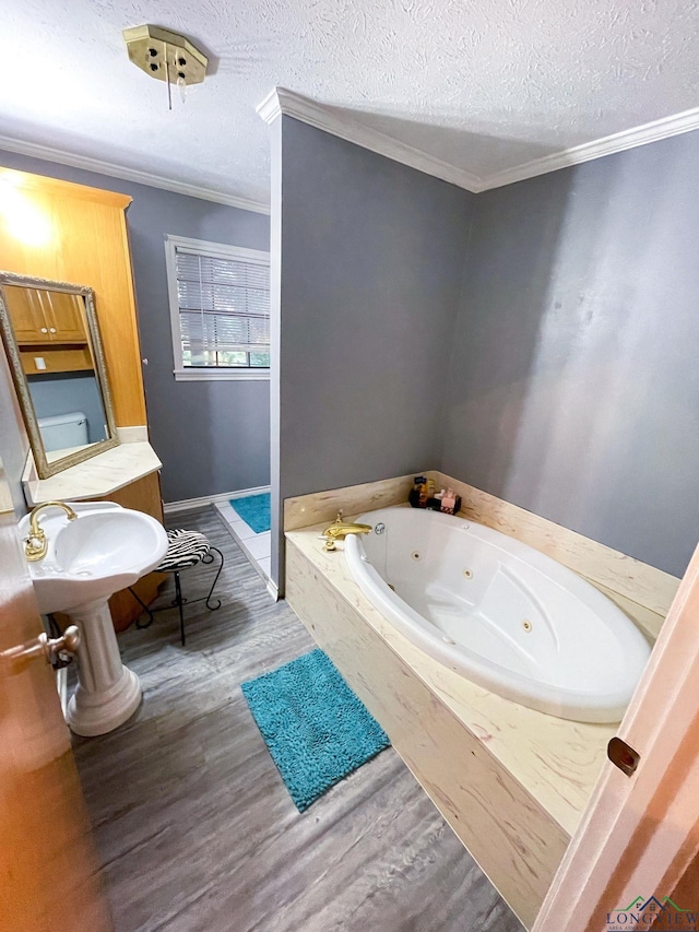 bathroom with hardwood / wood-style floors, a textured ceiling, toilet, a bathtub, and ornamental molding