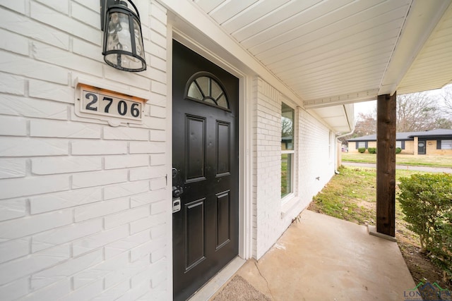 doorway to property featuring brick siding