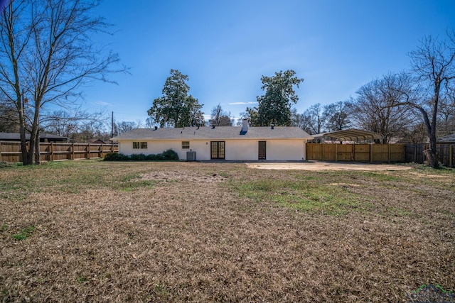 rear view of house with a garage, a lawn, concrete driveway, a patio, and a fenced backyard