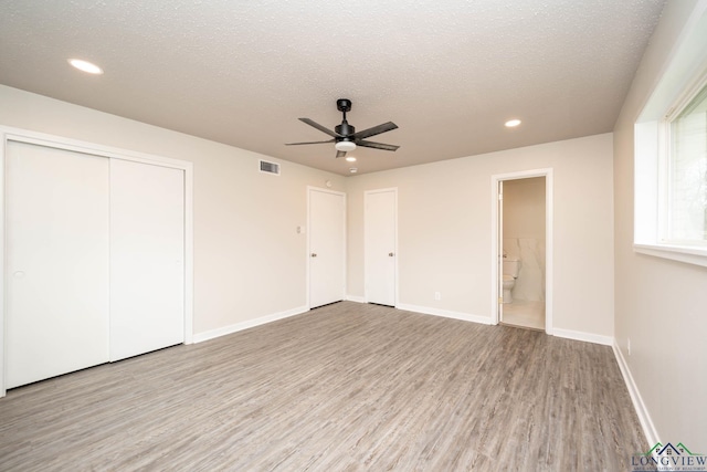 unfurnished bedroom featuring recessed lighting, visible vents, light wood-style flooring, a textured ceiling, and baseboards