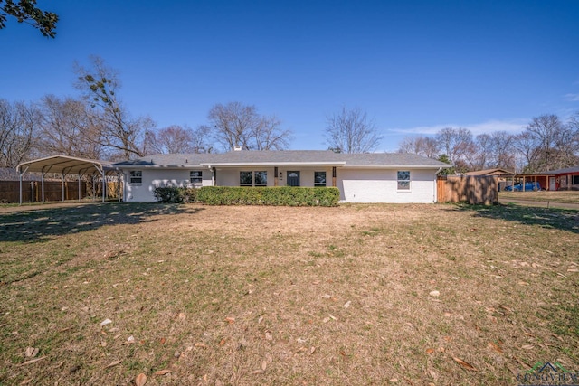 ranch-style home featuring a front yard, fence, and a detached carport