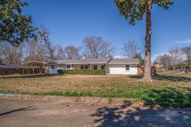 view of front of house with fence, a front lawn, and a detached carport