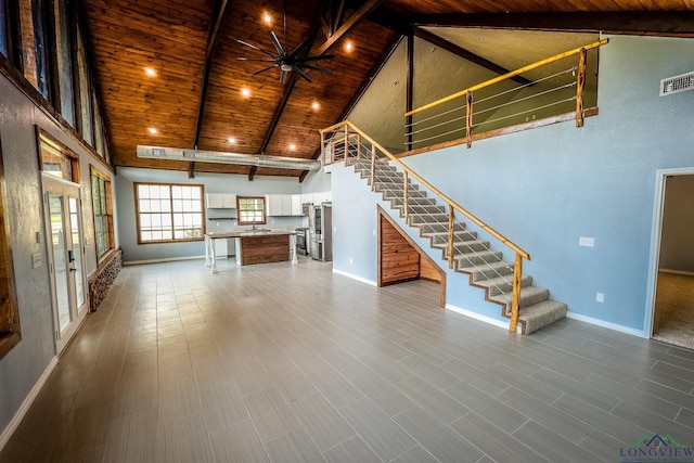 unfurnished living room featuring beamed ceiling, ceiling fan, wooden ceiling, and high vaulted ceiling