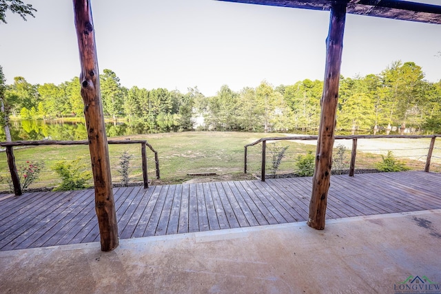 wooden terrace with a water view and a lawn