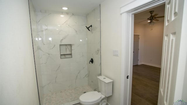 bathroom featuring a tile shower, toilet, ceiling fan, and hardwood / wood-style floors