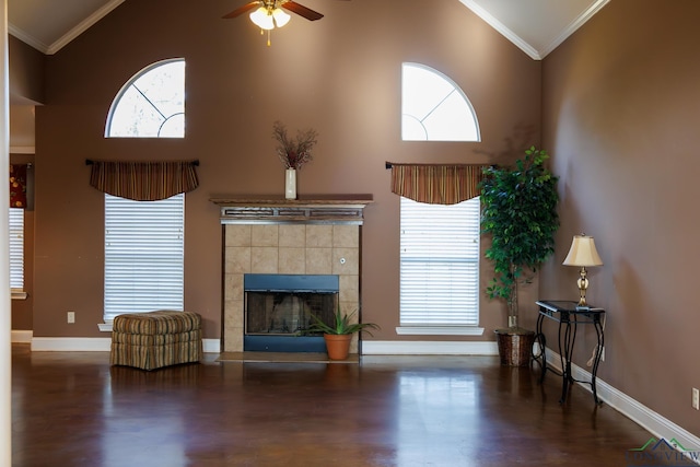 unfurnished living room featuring high vaulted ceiling, ceiling fan, a tile fireplace, and crown molding