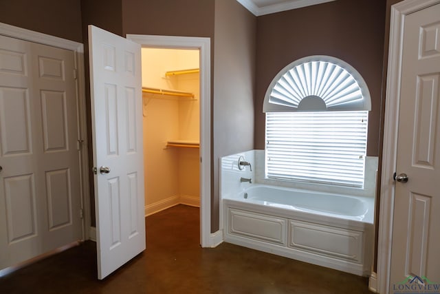 bathroom with concrete flooring, crown molding, and a washtub