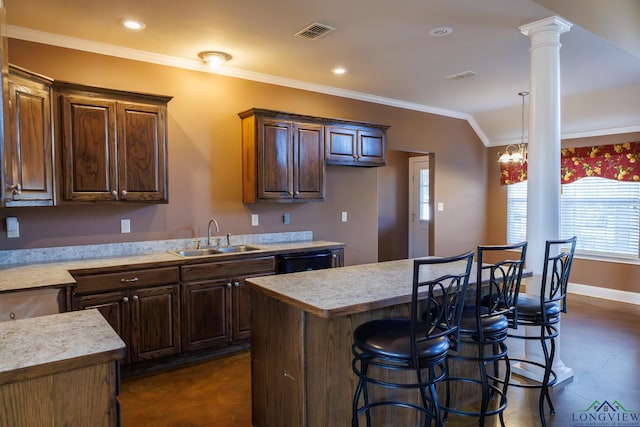 kitchen featuring a notable chandelier, a center island, sink, ornamental molding, and decorative columns