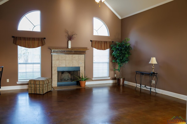 unfurnished living room with high vaulted ceiling, a tile fireplace, and ornamental molding