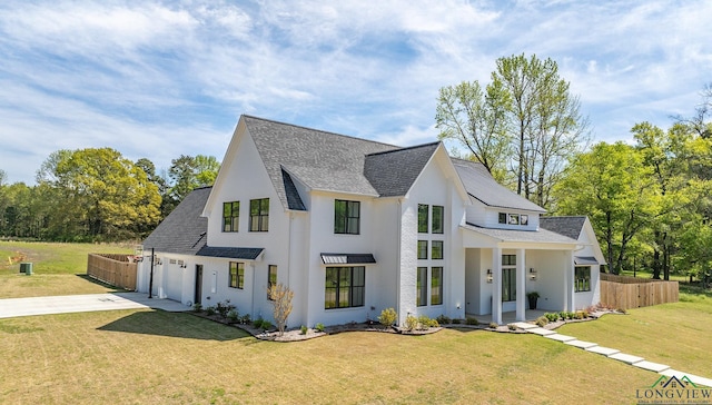 view of front of property featuring roof with shingles, driveway, a front lawn, a garage, and fence