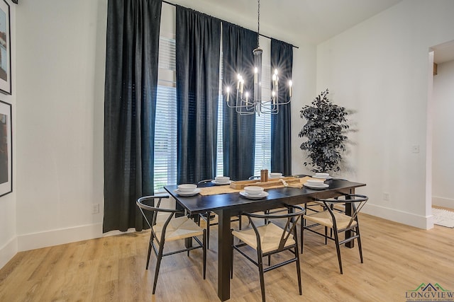 dining room with baseboards, light wood-type flooring, and a chandelier