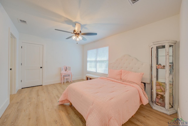 bedroom featuring baseboards, light wood finished floors, ceiling fan, and visible vents