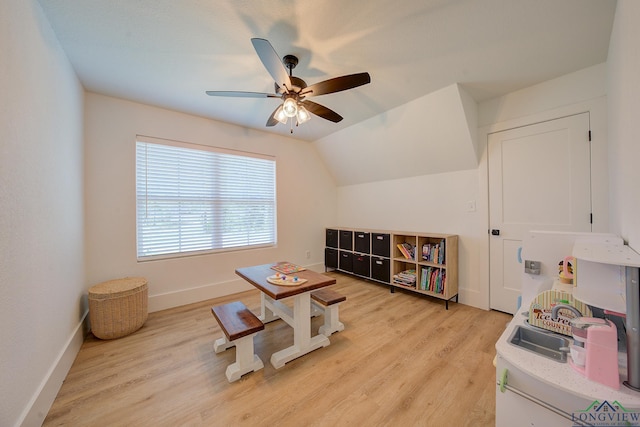 recreation room featuring light wood-style floors, baseboards, a ceiling fan, and lofted ceiling