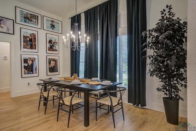 dining space with a chandelier, light wood-style flooring, and baseboards